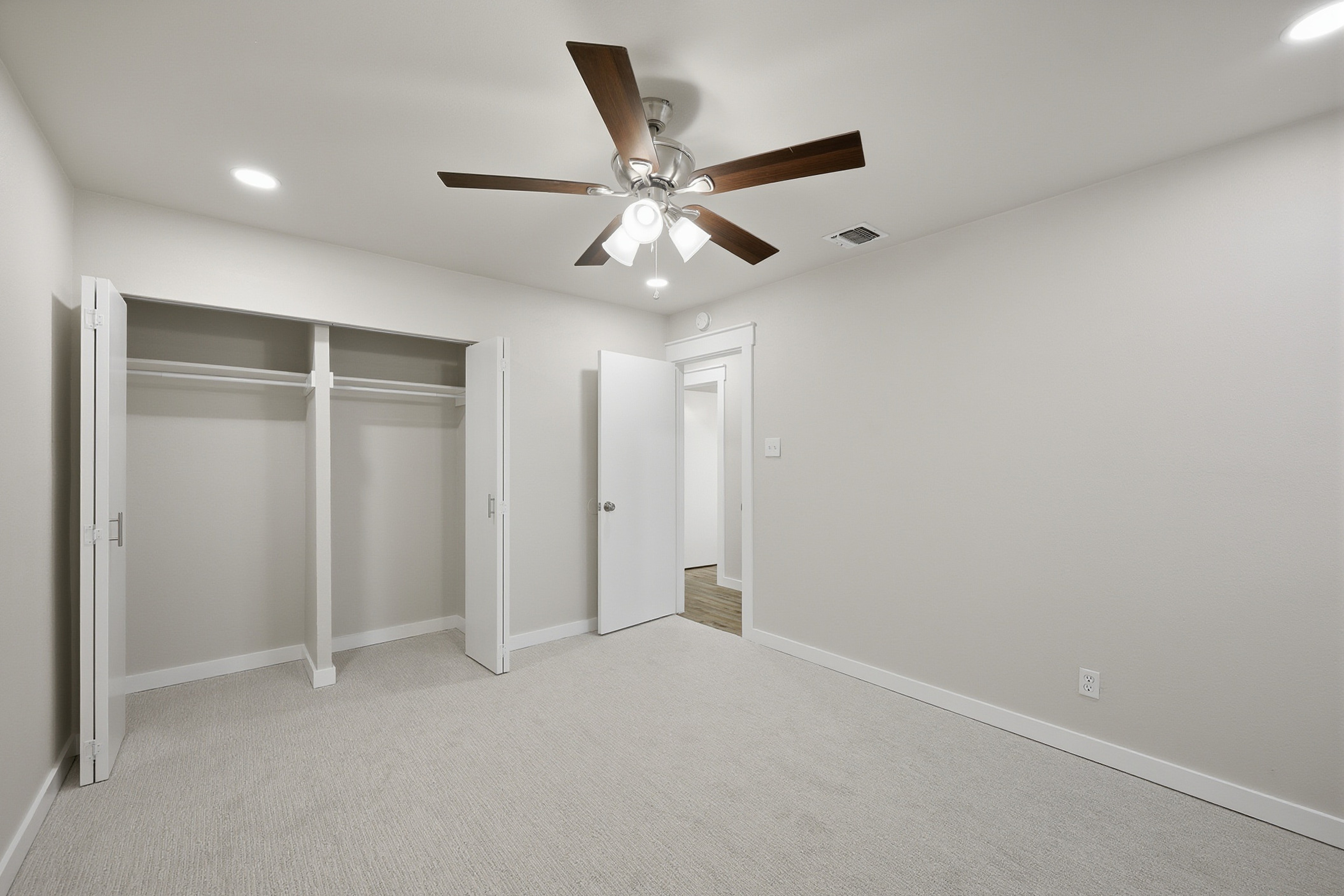 Bedroom with double-door closet, ceiling fan, and recessed lighting